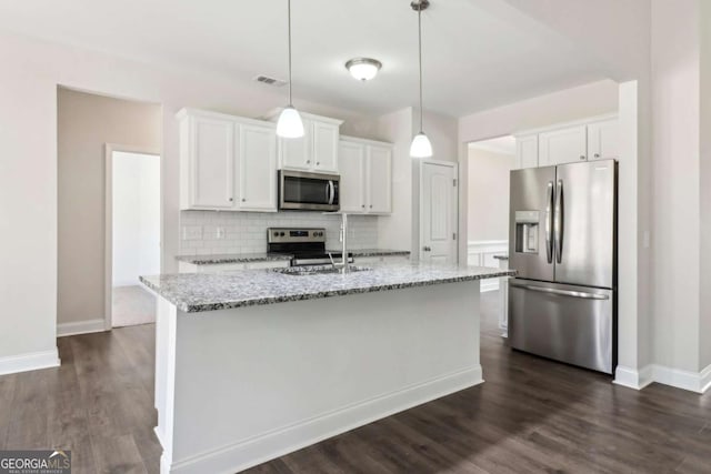 kitchen with stainless steel appliances, white cabinets, a center island with sink, and visible vents