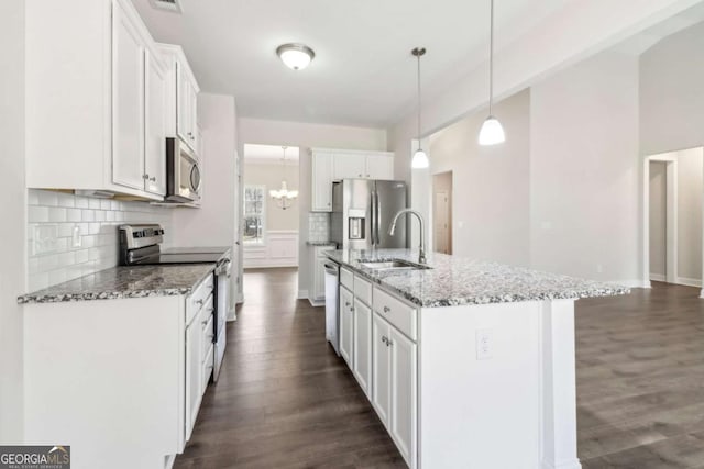 kitchen featuring pendant lighting, a center island with sink, appliances with stainless steel finishes, white cabinetry, and a sink