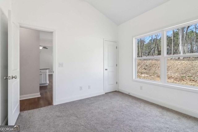 unfurnished bedroom with carpet, vaulted ceiling, and baseboards