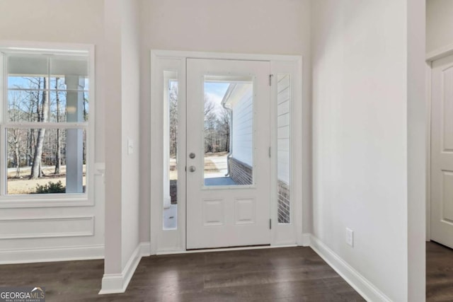 foyer featuring dark wood-type flooring and baseboards