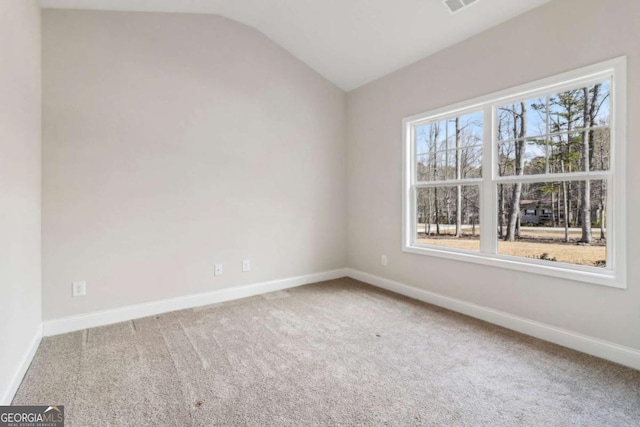 empty room with lofted ceiling, carpet floors, visible vents, and baseboards