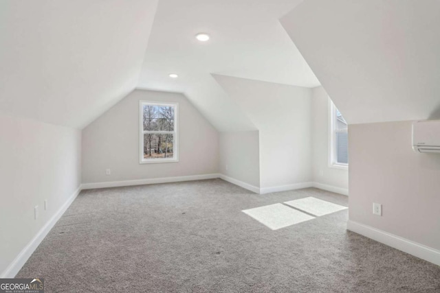 bonus room with lofted ceiling, recessed lighting, light colored carpet, a wall mounted air conditioner, and baseboards