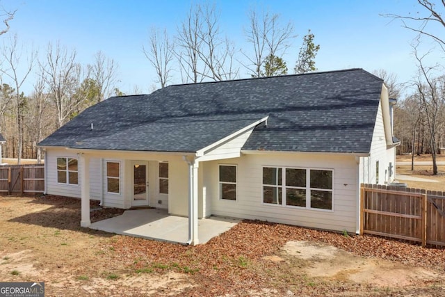 back of house featuring a patio area, a fenced backyard, and roof with shingles