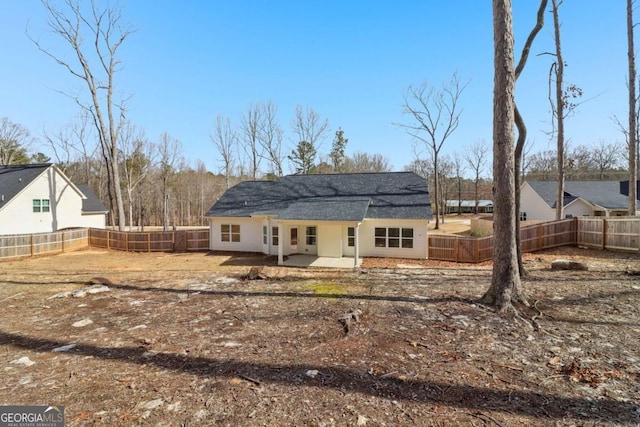 rear view of property with a fenced backyard and a patio