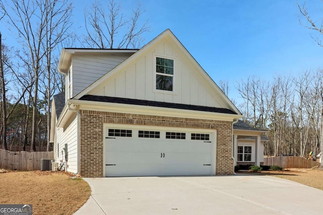 view of side of home with board and batten siding, brick siding, fence, and driveway