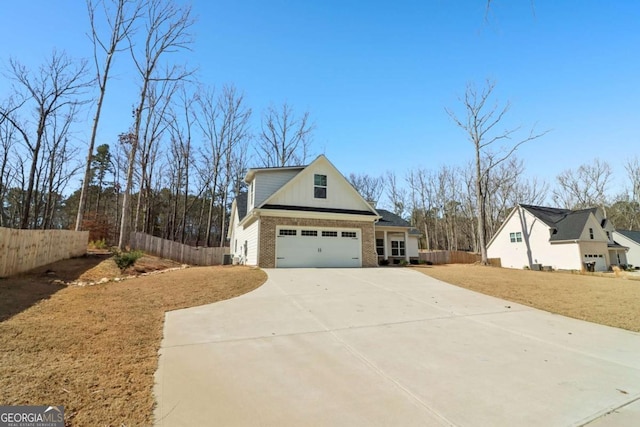 view of home's exterior featuring concrete driveway, brick siding, a lawn, and fence