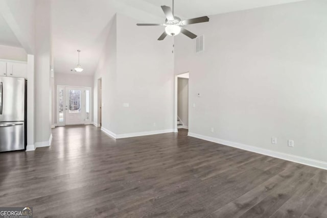 unfurnished living room with dark wood-style floors, visible vents, baseboards, and stairs