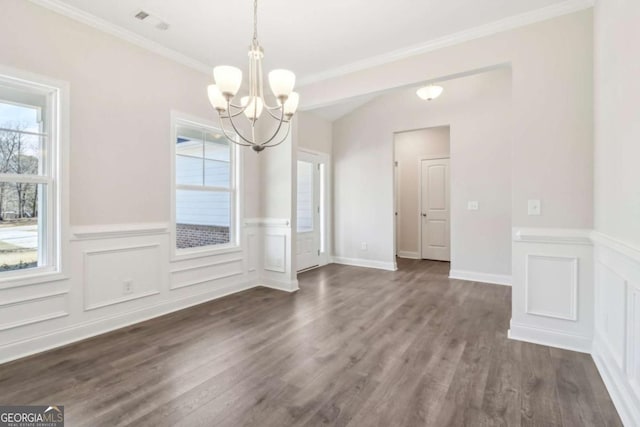 unfurnished dining area featuring dark wood-style floors, a notable chandelier, crown molding, and a wealth of natural light