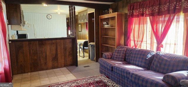 living room with light floors and wood walls