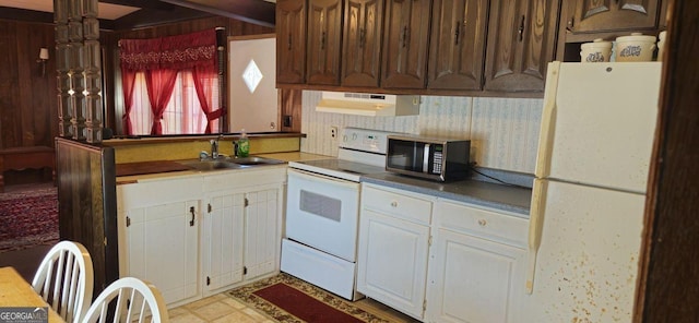 kitchen with white appliances, white cabinets, a sink, and under cabinet range hood