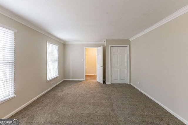 carpeted empty room with ornamental molding, visible vents, and baseboards