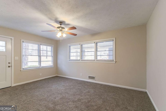 interior space with carpet, a textured ceiling, visible vents, and baseboards