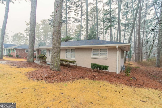 view of home's exterior with brick siding and a lawn