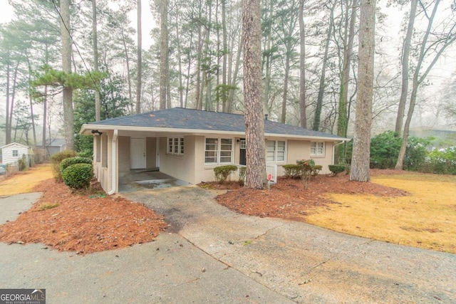 view of front of property with driveway, an attached carport, and brick siding