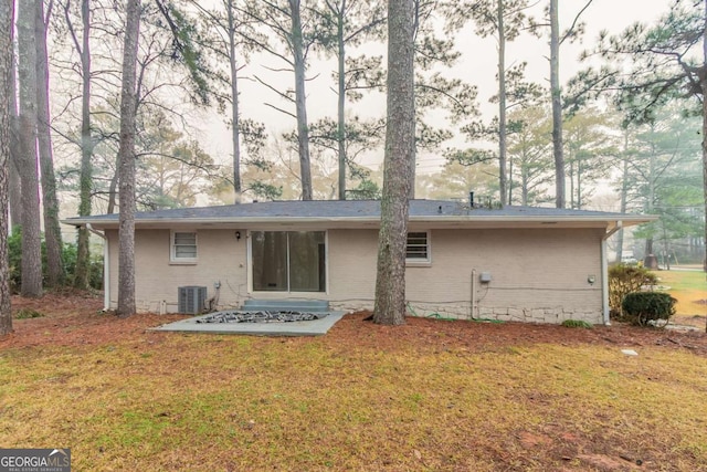 back of property featuring a yard and brick siding