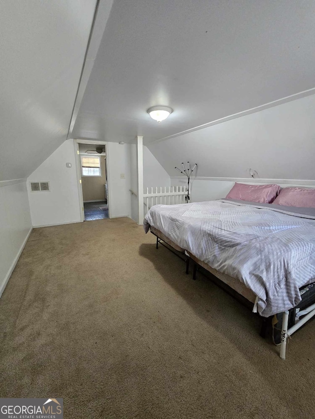 carpeted bedroom featuring visible vents and vaulted ceiling