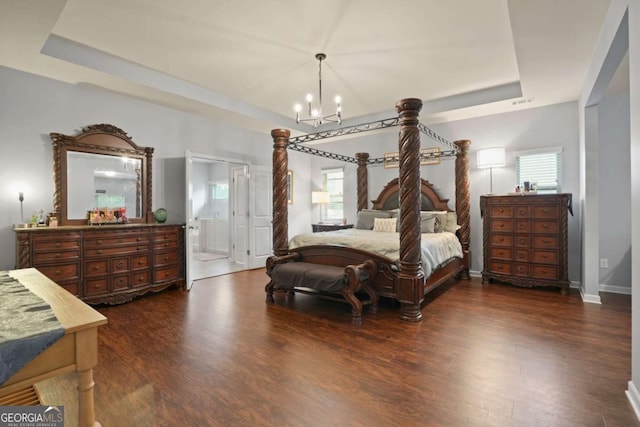 bedroom featuring dark wood-type flooring, a tray ceiling, baseboards, and an inviting chandelier