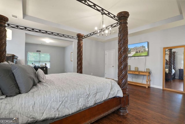 bedroom with dark wood-style floors, a raised ceiling, and baseboards