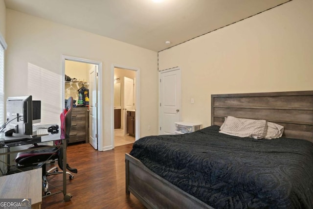 bedroom with dark wood-style floors, a spacious closet, a closet, and ensuite bath