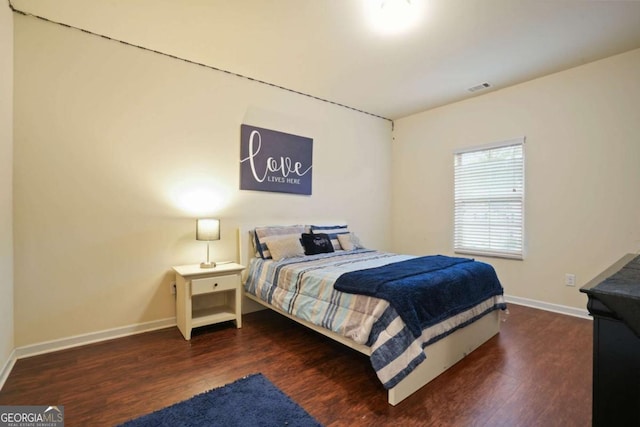 bedroom featuring dark wood-style floors, visible vents, and baseboards