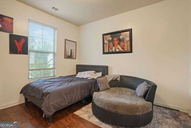 bedroom with baseboards, visible vents, and dark wood finished floors