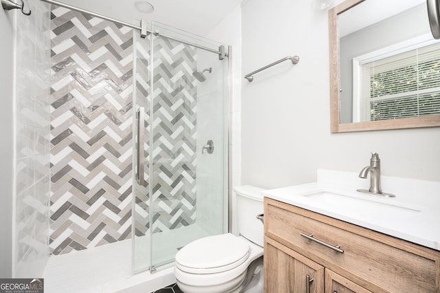 full bath with vanity, a shower stall, and toilet