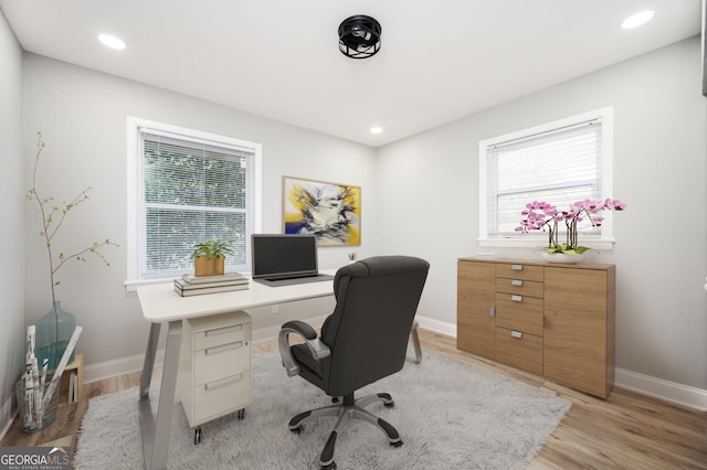 office with recessed lighting and light wood-style floors