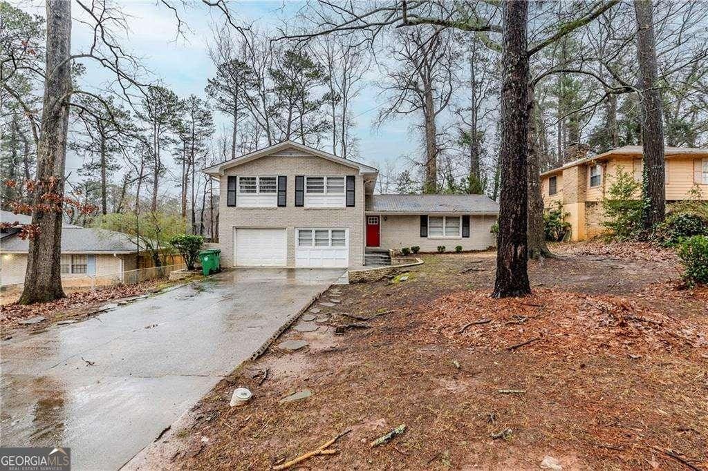 split level home with a garage and aphalt driveway