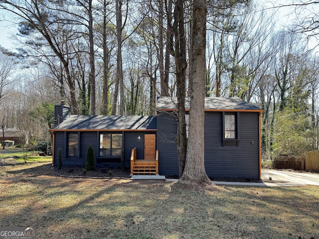 view of front of house with a chimney and a front lawn