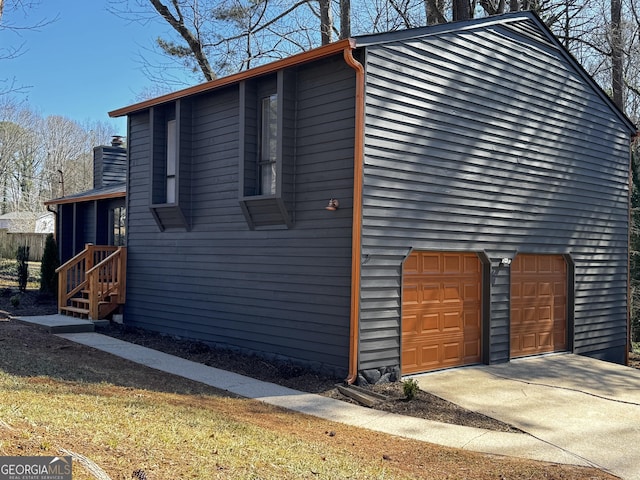 view of side of home featuring concrete driveway