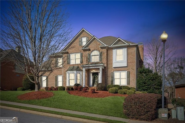 view of front of property featuring brick siding and a front lawn