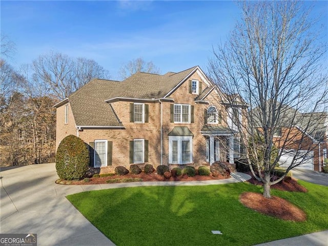 colonial inspired home with driveway and a front yard