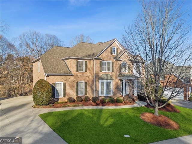 view of front of property with driveway, a front lawn, and roof with shingles