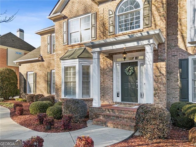 view of exterior entry featuring brick siding