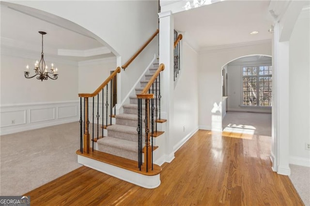 3690 Millwater Xing, Dacula, GA 30019 - stairway with arched walkways, crown molding, a chandelier, and wood finished floors