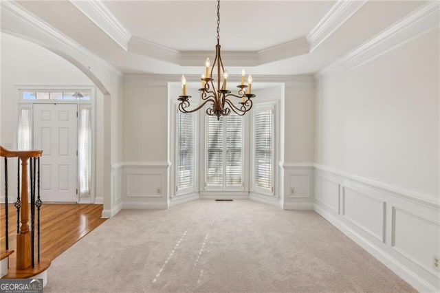 3690 Millwater Xing, Dacula, GA 30019 - unfurnished dining area featuring a chandelier, arched walkways, carpet, a decorative wall, and ornamental molding