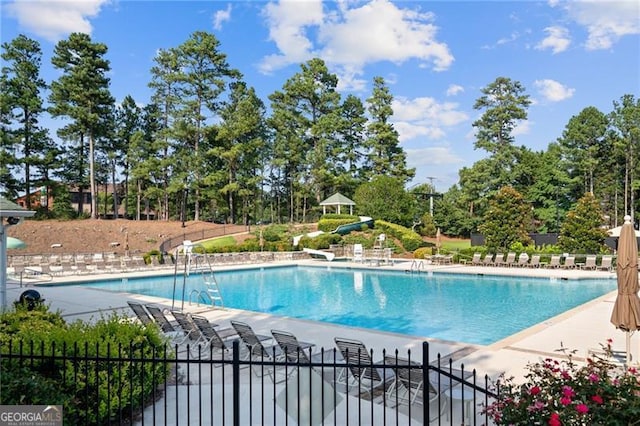 3690 Millwater Xing, Dacula, GA 30019 - community pool with a water slide, a patio area, and view of wooded area