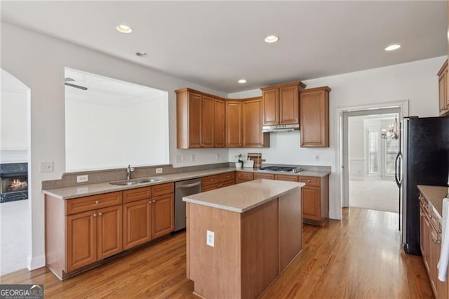 3690 Millwater Xing, Dacula, GA 30019 - kitchen featuring appliances with stainless steel finishes, under cabinet range hood, a center island, light wood-style floors, and a high end fireplace