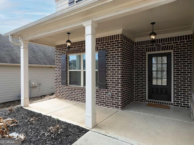 doorway to property featuring brick siding