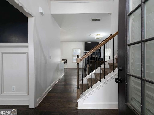 stairs featuring visible vents, baseboards, and wood finished floors