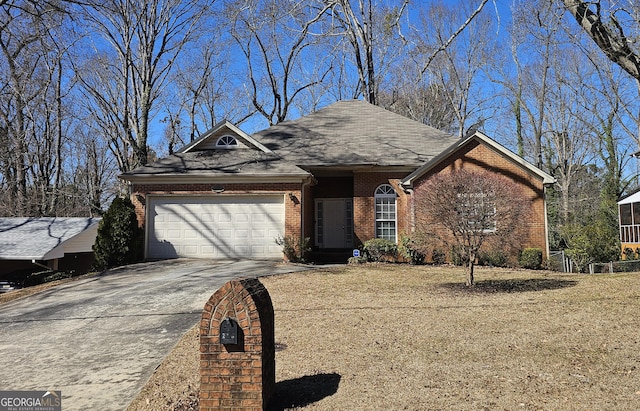 ranch-style home featuring a garage, a front yard, brick siding, and driveway