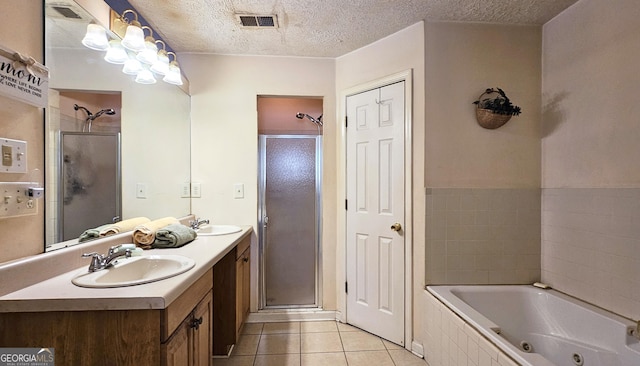 full bath featuring a tub with jets, a sink, visible vents, and tile patterned floors