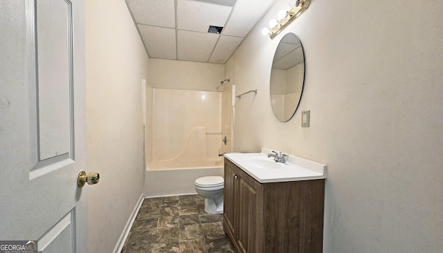 bathroom featuring baseboards, toilet, vanity, a paneled ceiling, and shower / bathing tub combination