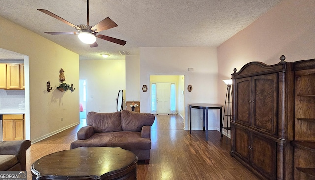 living area with a textured ceiling, ceiling fan, wood finished floors, and baseboards