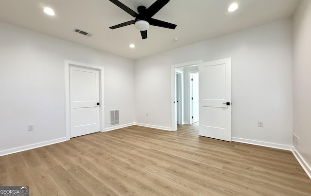 empty room with visible vents, light wood-style flooring, and baseboards