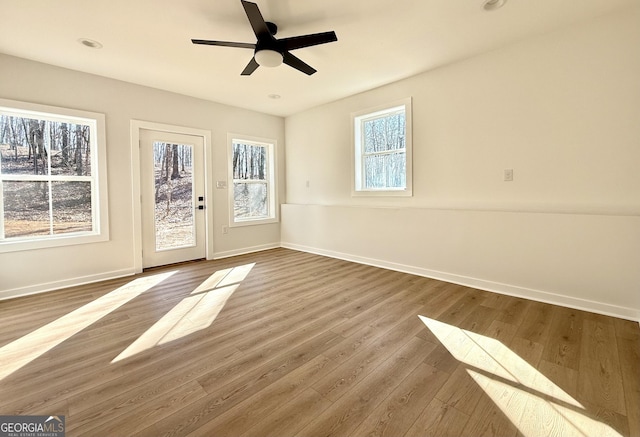 empty room with ceiling fan, baseboards, wood finished floors, and recessed lighting