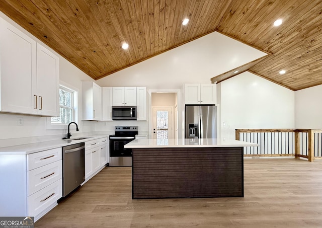 kitchen featuring light countertops, appliances with stainless steel finishes, white cabinets, a kitchen island, and a sink