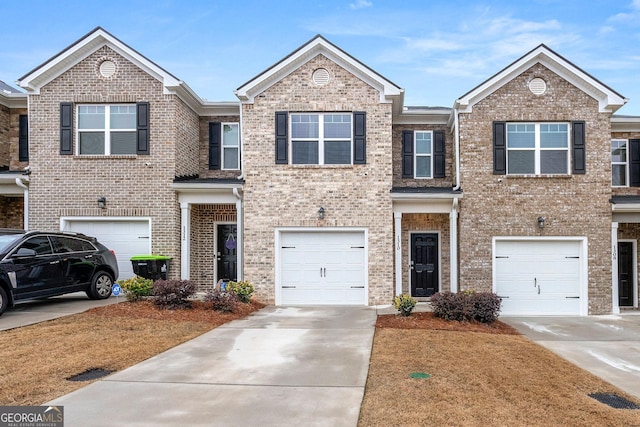 view of front of property with an attached garage, concrete driveway, and brick siding