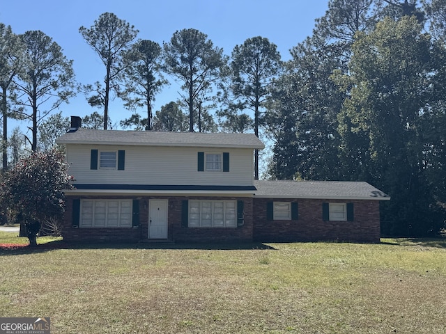 traditional-style house featuring a front lawn and brick siding