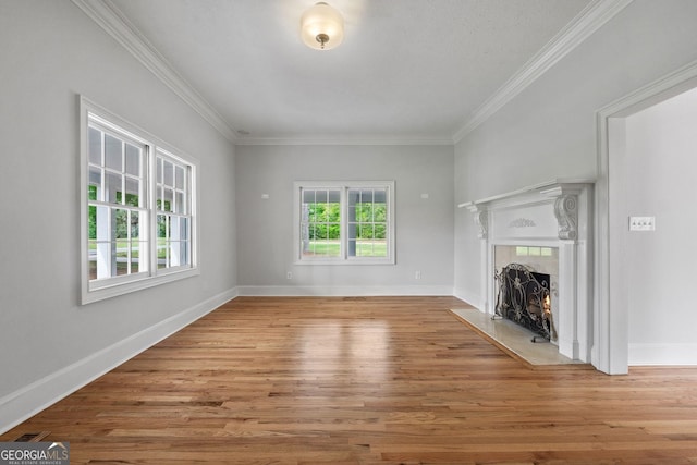 unfurnished living room featuring visible vents, baseboards, crown molding, light wood-style floors, and a fireplace